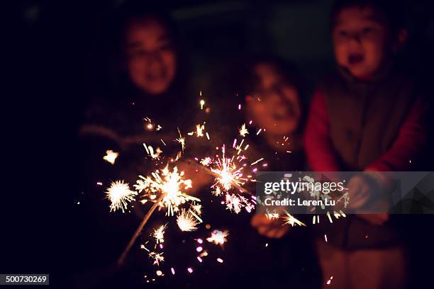 kid playing sparklers at night - sparklers stock pictures, royalty-free photos & images