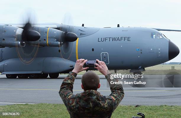 Member of the Bundeswehr, the German armed forces, snaps a photo of a Luftwaffe A-400M plane transporting 40 Bundeswehr members and their equipment...