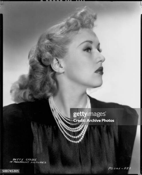 Profile portrait of actress Betty Grable wearing a pearl necklace, for Paramount Studios, 1938.
