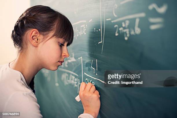 little girl writing difficult mathematics equations - mathematical symbol stock pictures, royalty-free photos & images