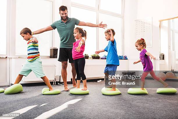 small children walking on pilates balls on training class. - sports training facility stock pictures, royalty-free photos & images