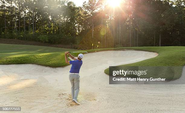 golf player hitting ball out of sand trap - sand trap stock pictures, royalty-free photos & images