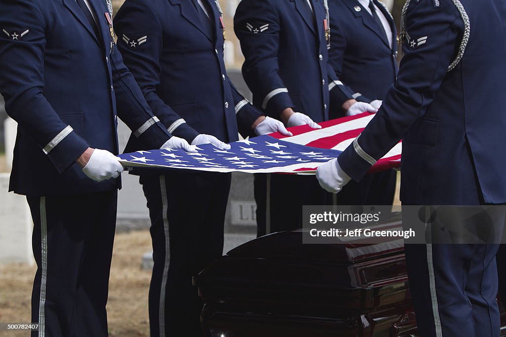 Soldiers folding flag at military funeral