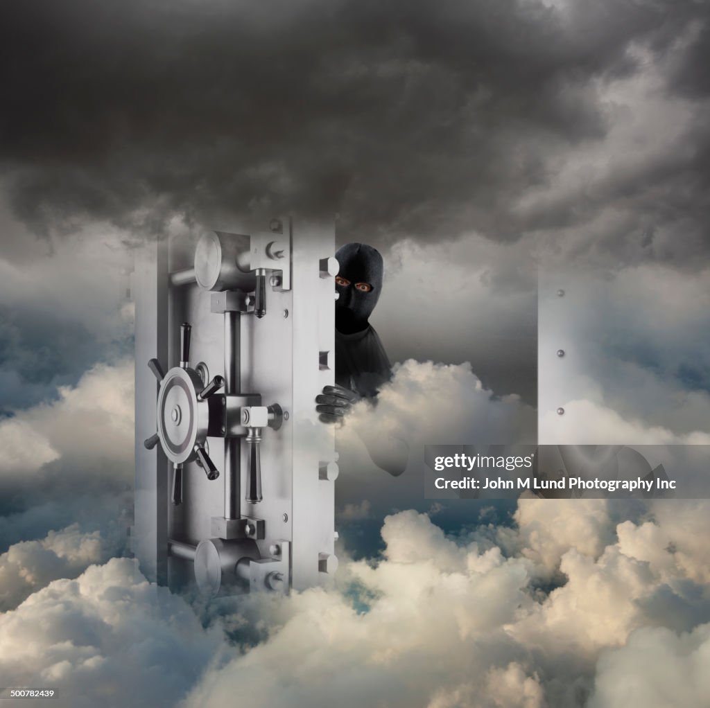 Caucasian robber opening bank vault in clouds