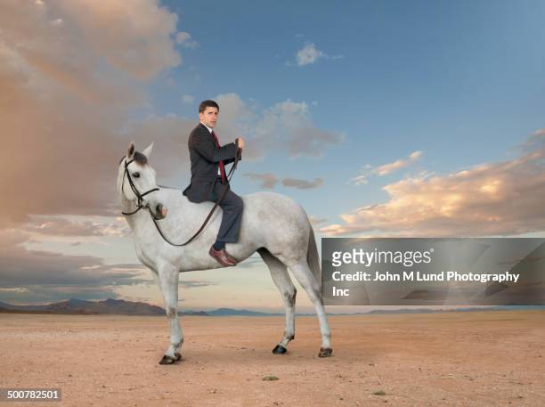 middle eastern businessman riding horse backwards - all horse riding imagens e fotografias de stock