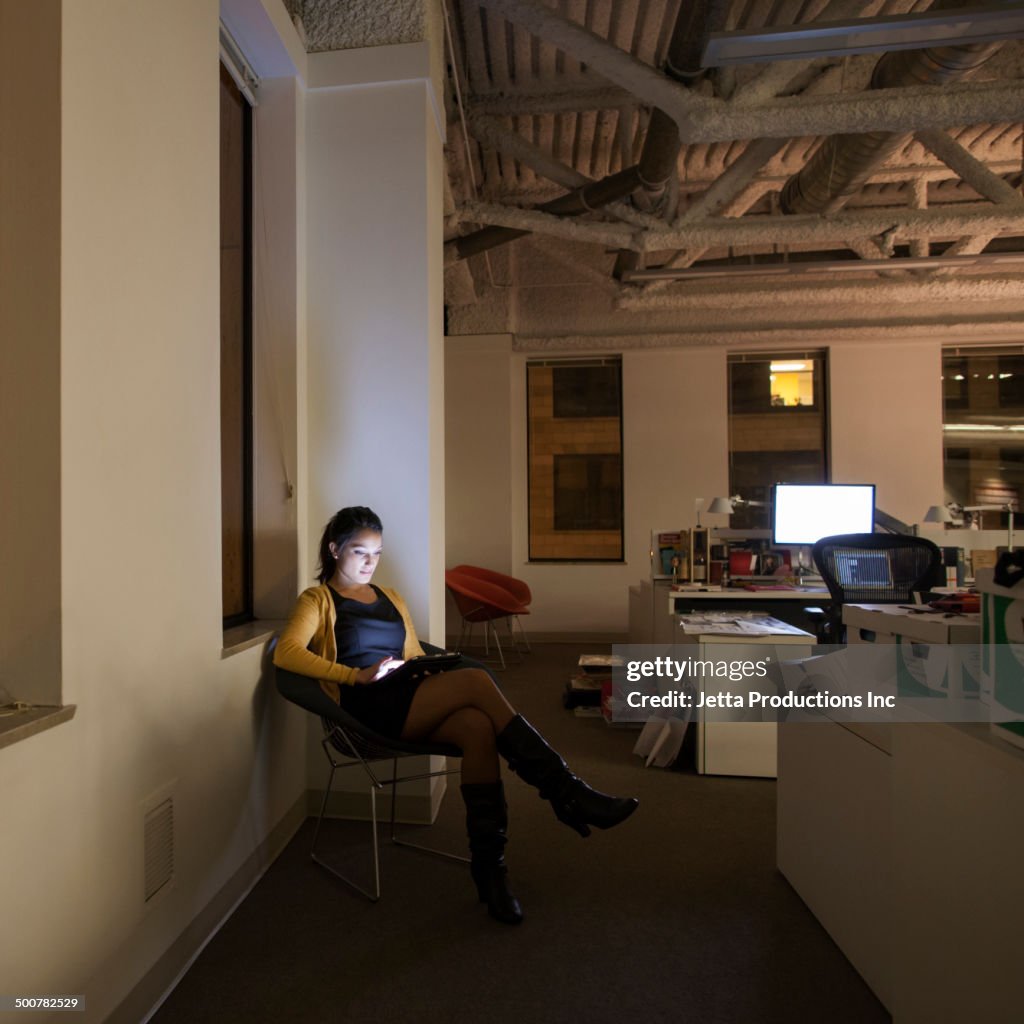 Mixed race businesswoman working late in office