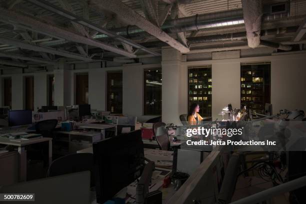 mixed race businesswoman working late in office - working late stock-fotos und bilder