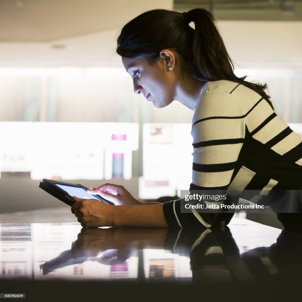 Mixed race businesswoman using digital tablet in office