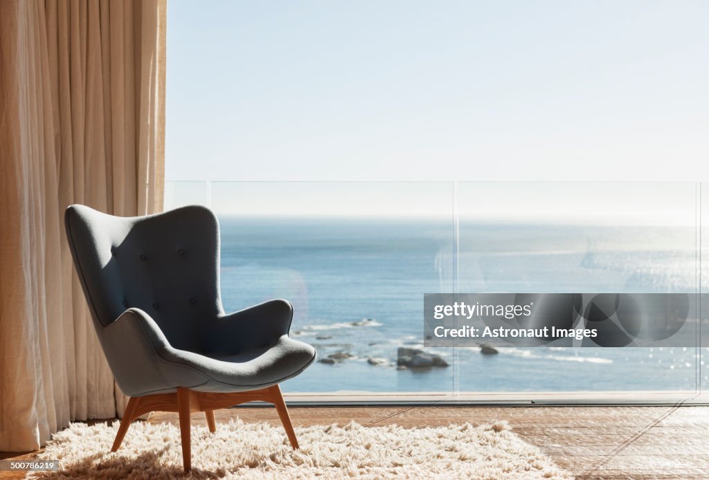 Chair in sunny window overlooking ocean