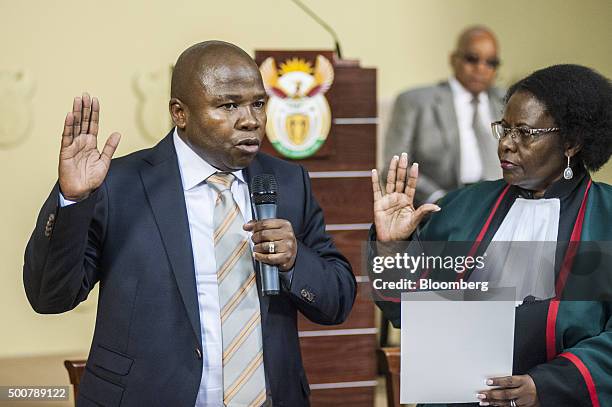 Jacob Zuma, South Africa's president, center, watches as David van Rooyen, South Africa's incoming finance minister, left, is sworn into office by...