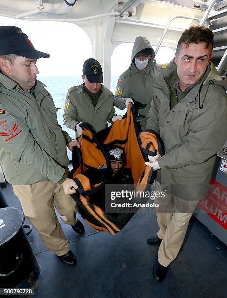 Turkish Coast Guard ship TCSG Umut crew members carry a wheel chair bound refugee man on December 10, 2015 after refugees and asylum seekers were...