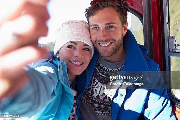 couple talking selfie in ski lift - knit hat stock pictures, royalty-free photos & images