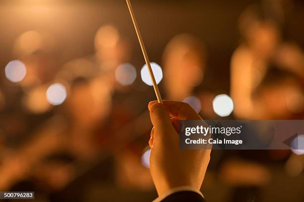 close up of orchestra conductor holding baton - conductor leading orchestra stock-fotos und bilder