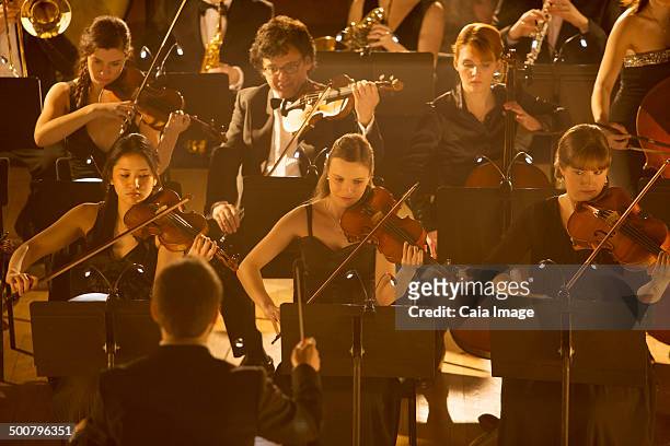 orchestra performing - conductor leading orchestra stock-fotos und bilder
