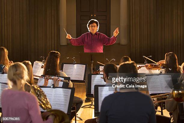 conductor leading orchestra - conductor leading orchestra stock-fotos und bilder