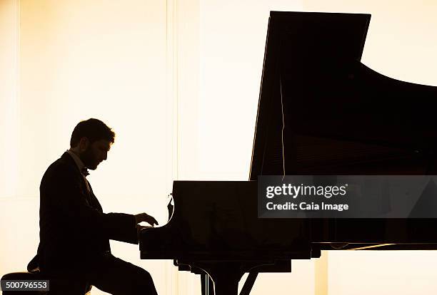 silhouette of pianist performing - pianist stock pictures, royalty-free photos & images