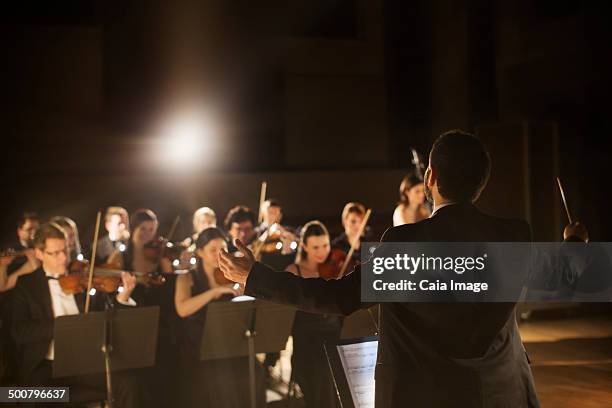 conductor leading orchestra - orchestra conductor foto e immagini stock