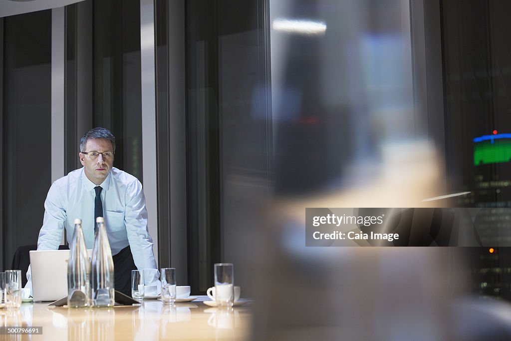 Businessman in conference room at night