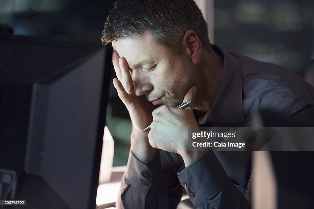 Tired businessman working late at computer