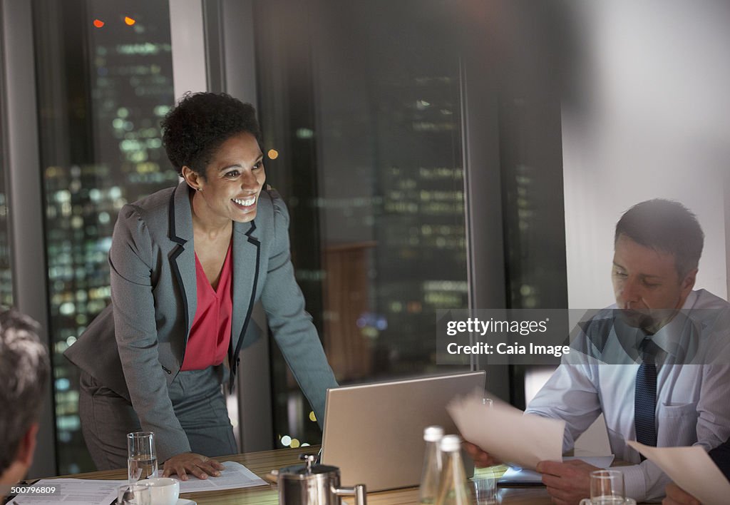 Business people meeting in conference room at night