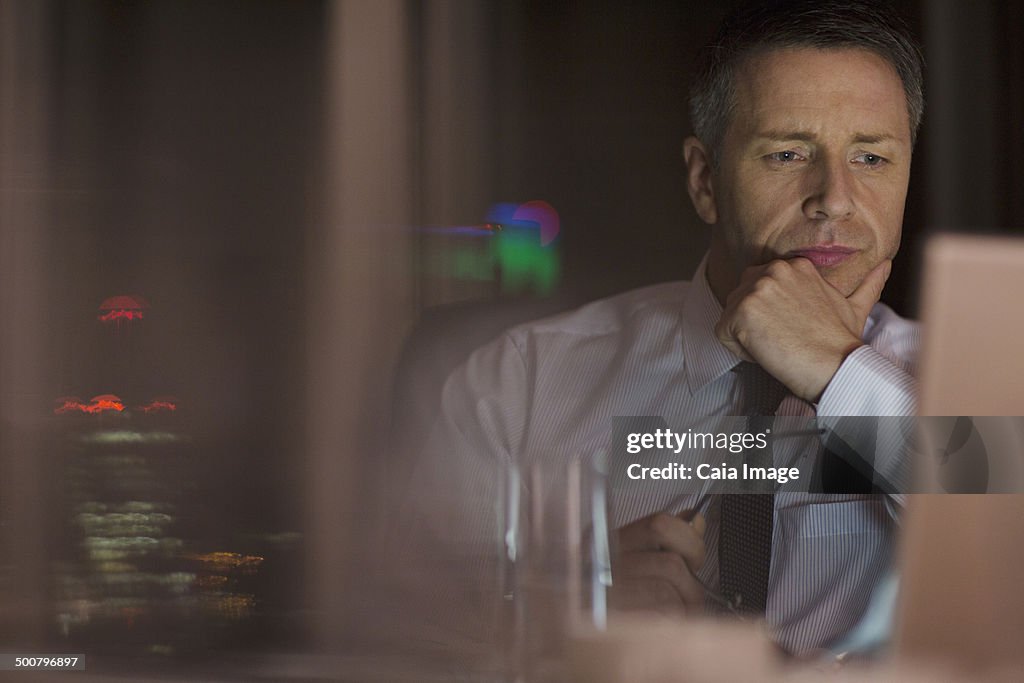 Pensive businessman working late at laptop in office