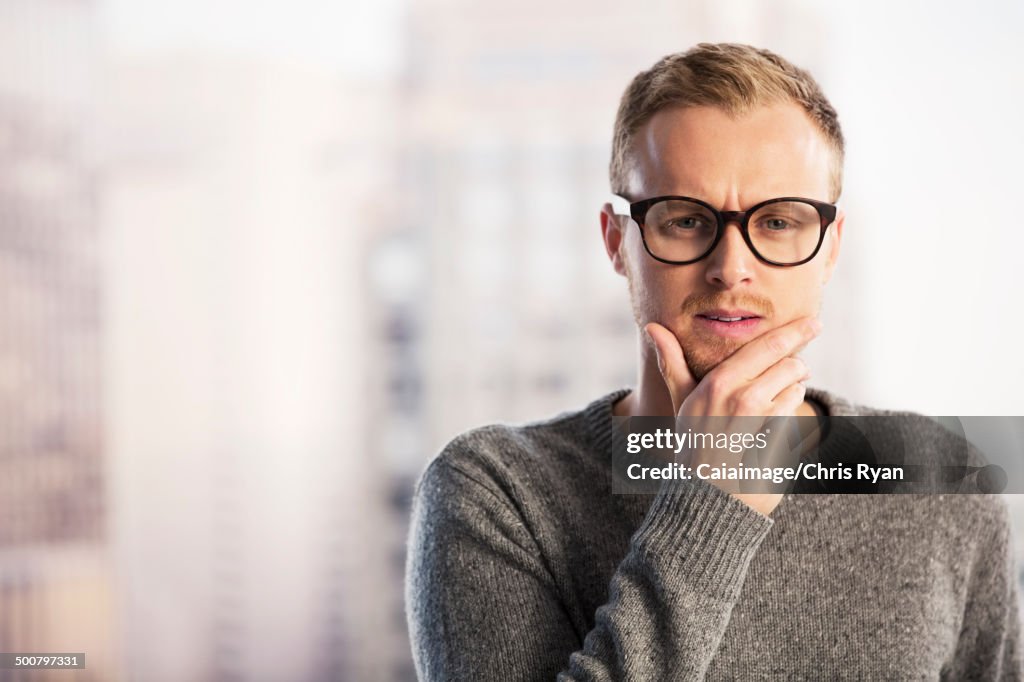 Pensive businessman with hand on chin