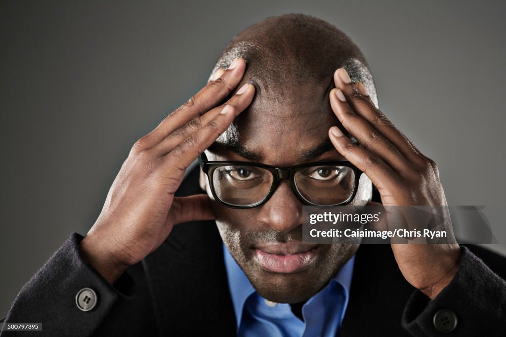 Portrait of stressed businessman with head in hands