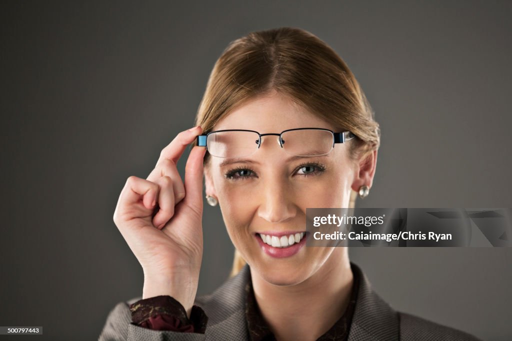 Ritratto di donna d'affari fiduciosa che alza gli occhiali