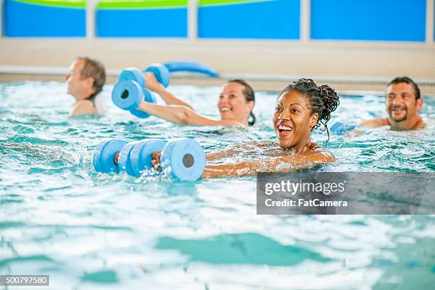 frau einen aerobic-kurs im pool - aquarobics stock-fotos und bilder
