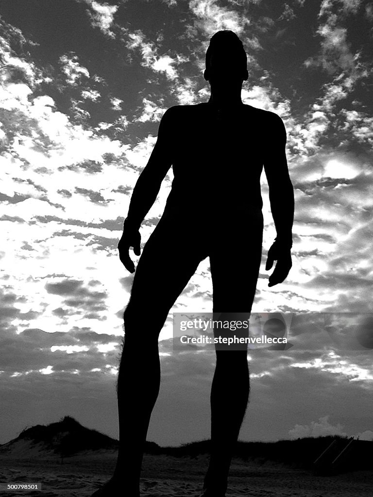 Silhouette of nude man on beach