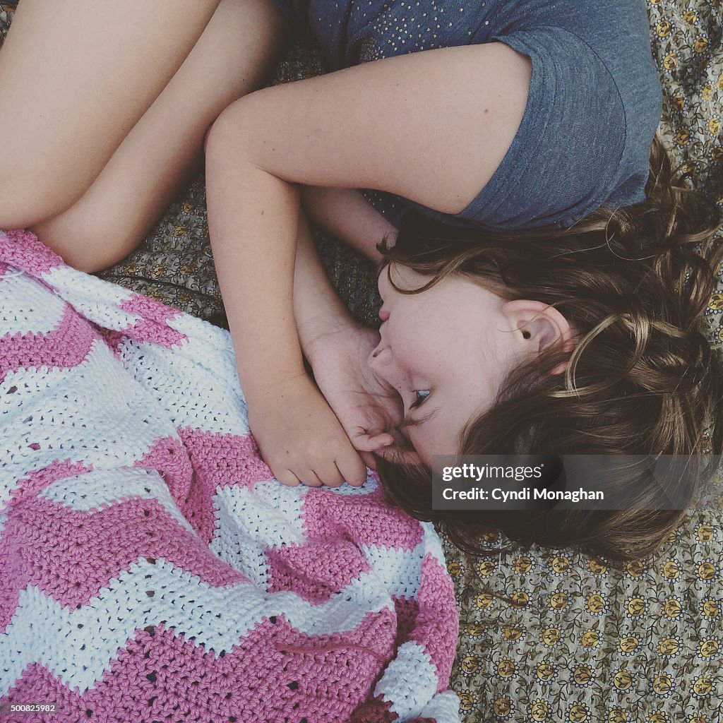 Girl Curled up with Crochet Blanket