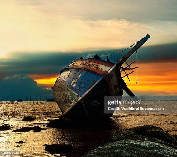 wreck ship at twilight - vudhikrai stock-fotos und bilder