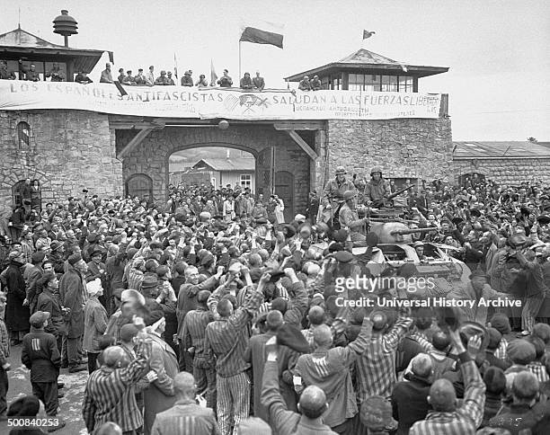 Tanks of U.S. 11th Armoured Division entering the Mauthausen concentration camp; banner in Spanish reads "Antifascist Spaniards greet the forces of...