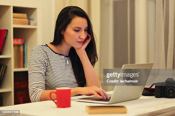 young brunette arbeiten am laptop - brunette sitting at desk stock-fotos und bilder