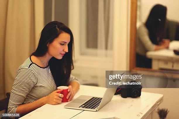 young brunette arbeiten am laptop - brunette sitting at desk stock-fotos und bilder