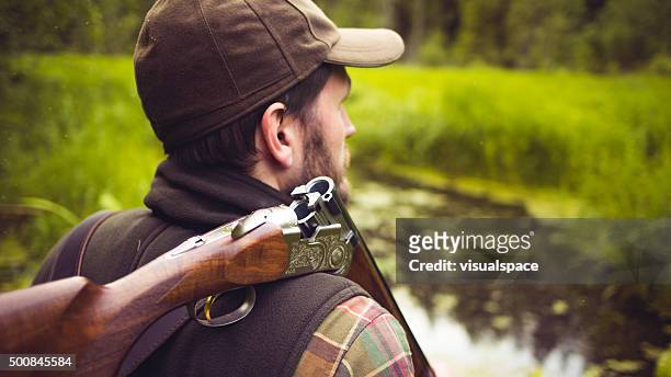 hunter with open shotgun on shoulder - shotgun stock pictures, royalty-free photos & images