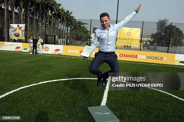 Chief executive officer and founder Pavegen Laurence Kemball-Cook jumps holding solar light during the unveiling of Africa's first kinetic football...