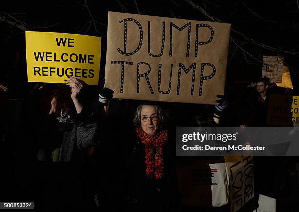 Woman holds a sign outside the Sheraton Portsmouth Harborside Hotel where Republican presidential candidate Donald Trump is due to speak at the New...