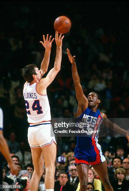 Bobby Jones of the Philadelphia 76ers shoots over Albert King of the New Jersey Nets during an NBA basketball game circa 1984 at The Spectrum in...
