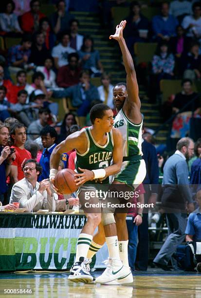 Dennis Johnson of the Boston Celtics looks to pass the ball by Sidney Moncrief of Milwaukee Bucks during an NBA basketball game circa 1986 at the...