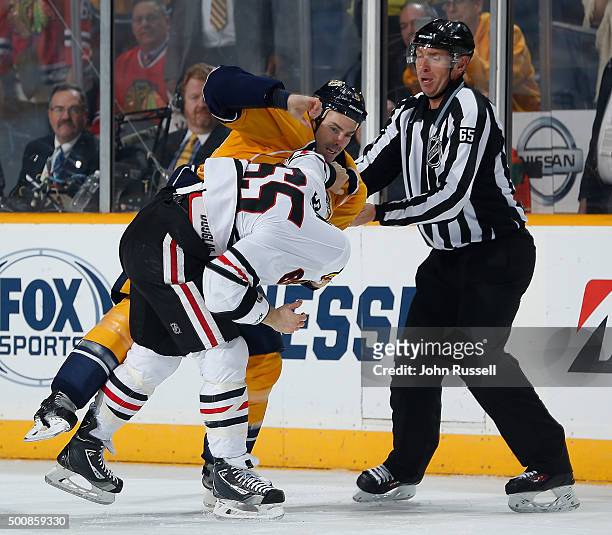 Linesman Pierre Racicot skates in to separate Barret Jackman of the Nashville Predators and Andrew Shaw of the Chicago Blackhawks during an NHL game...