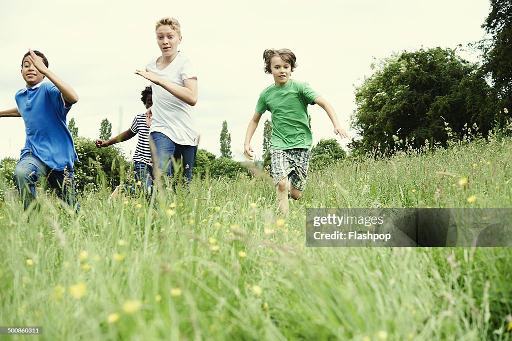 Group of friends running through a field