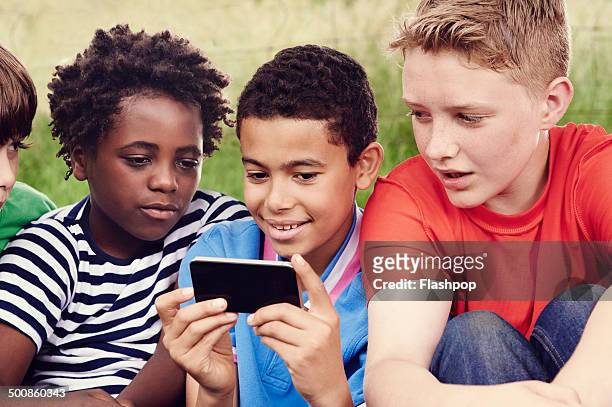 group of friends looking at video on phone - só meninos - fotografias e filmes do acervo