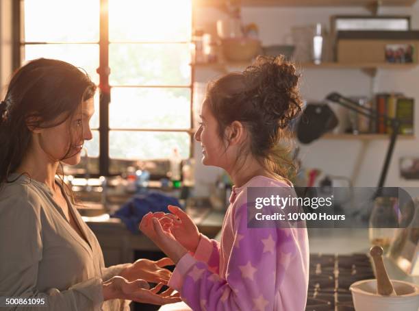 a mother and teenage daughter chatting playfully - two kids looking at each other stockfoto's en -beelden