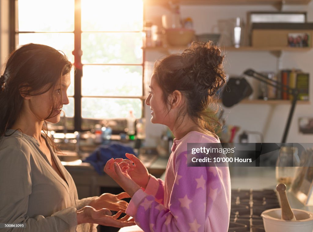 A mother and teenage daughter chatting playfully