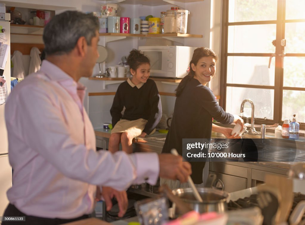 Family chatting and cooking an evening meal