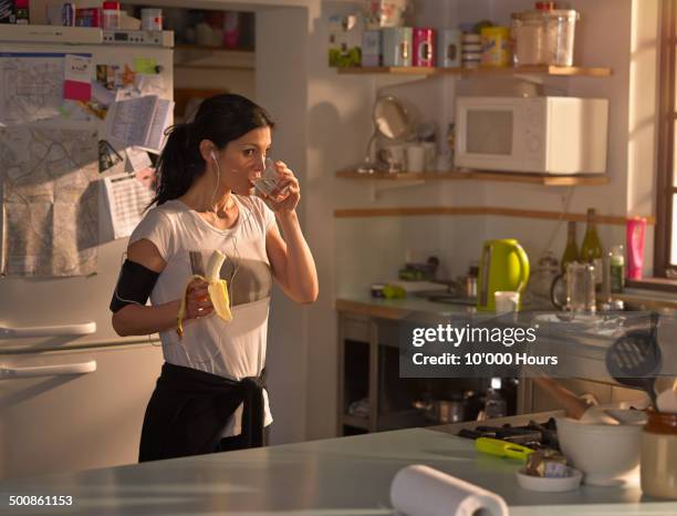 woman in the kitchen preparing for run - banana ストックフォトと画像