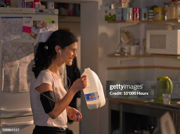 a woman in her kitchen after a run - calcio sport imagens e fotografias de stock