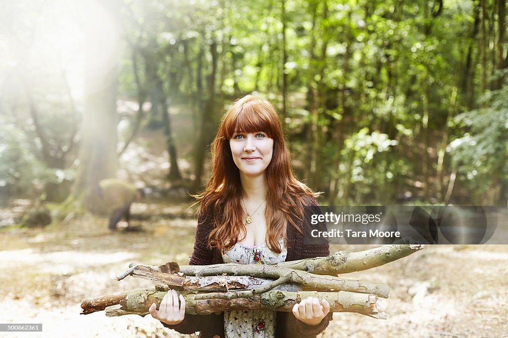 Woman in forest collecting firewood
