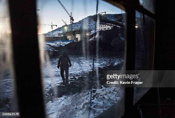 Chinese coal mine worker walks in a sorting area at a coal mine on November 25, 2015 in Shanxi, China. A history of heavy dependence on burning coal...